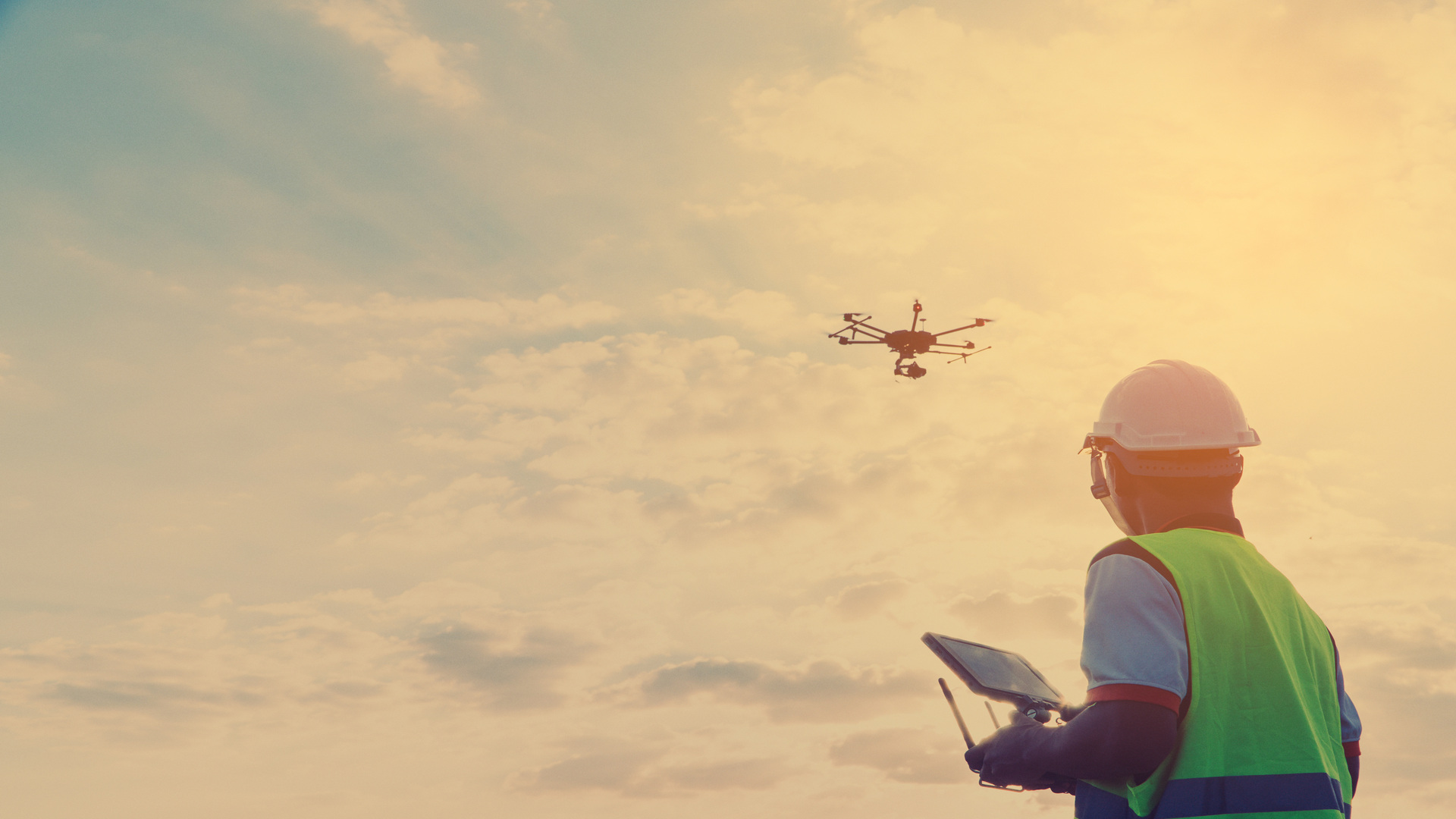 Person flying drone looking up 