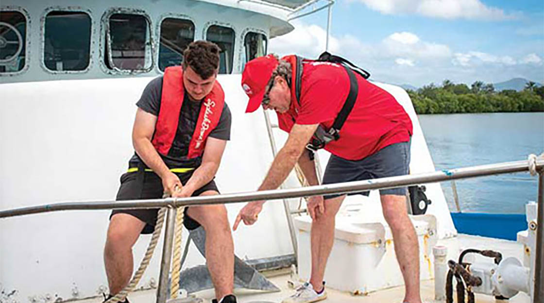 students on boat using rope to tie a knot