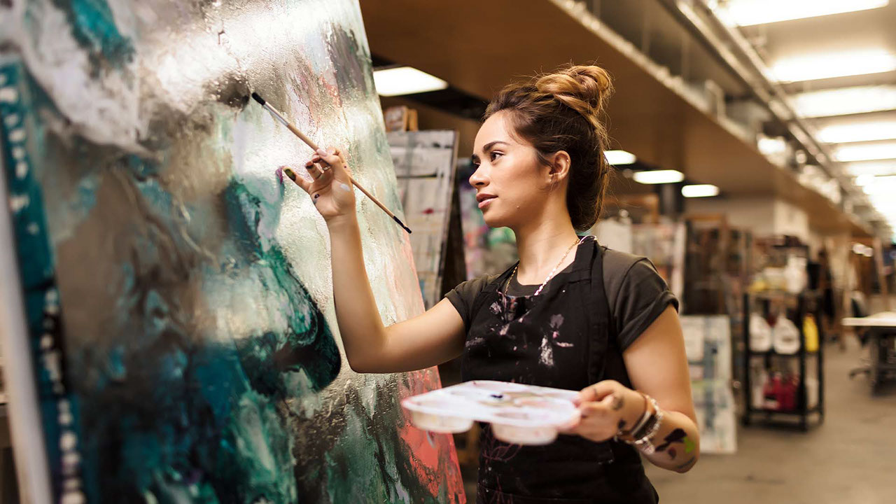 TAFE Queensland visual arts student painting on large canvas
