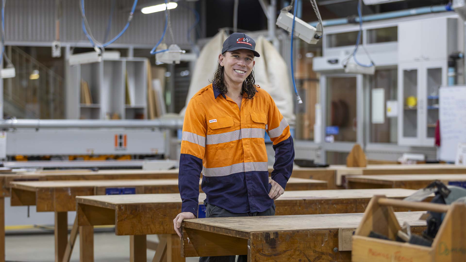 Student Jye looks into camera with electrical training workshop in background