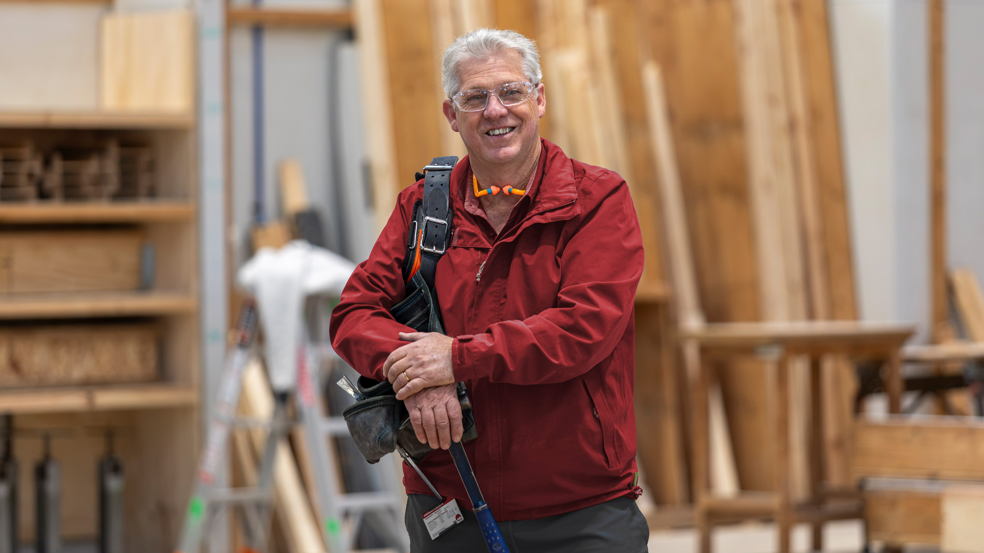 Stephen looking at camera with campus carpentry workshop in background