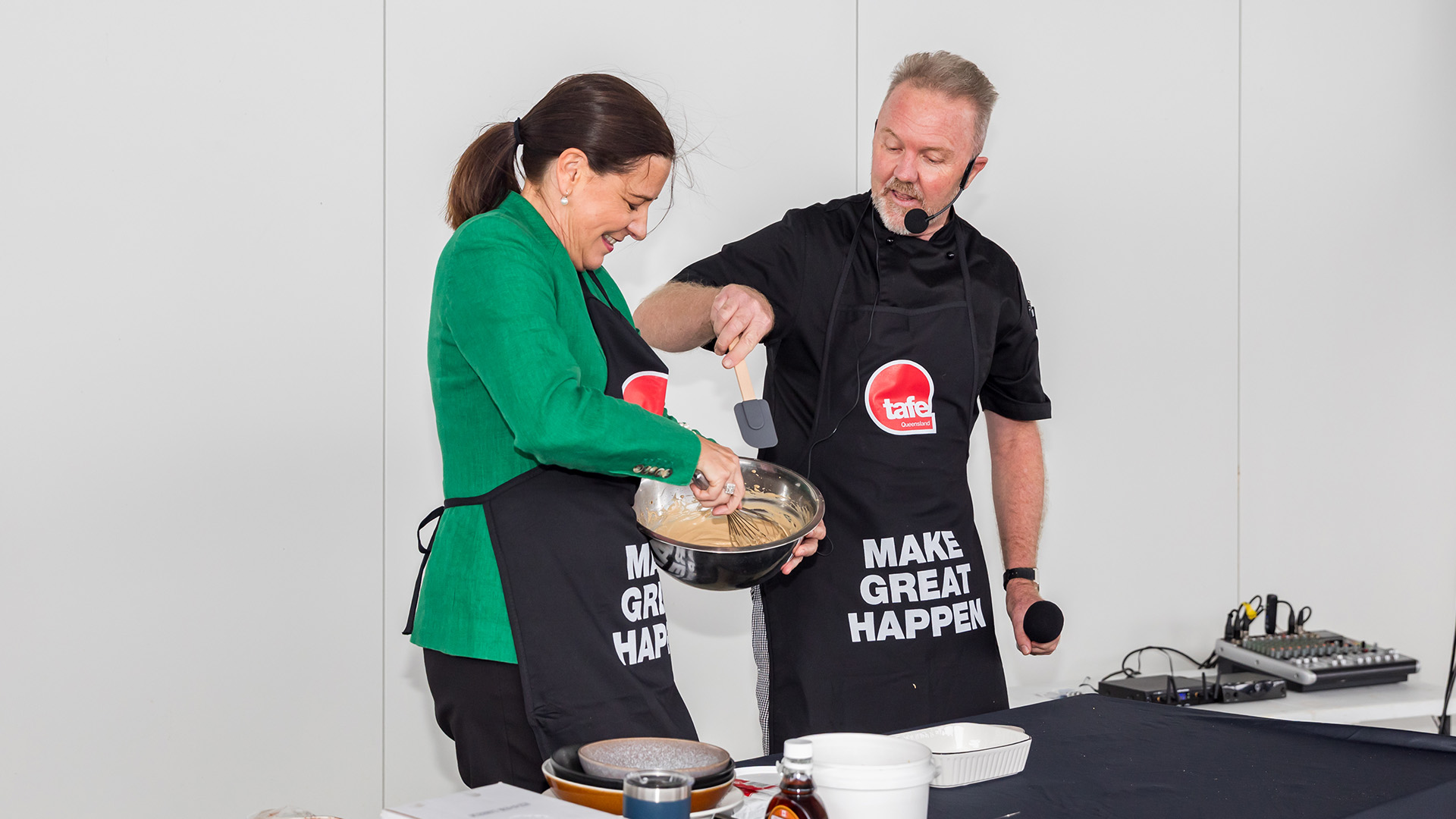 Queensland Attorney-General, Deb Frecklington assists TAFE Queensland cookery educator, Jason Ford, with a live demonstration.