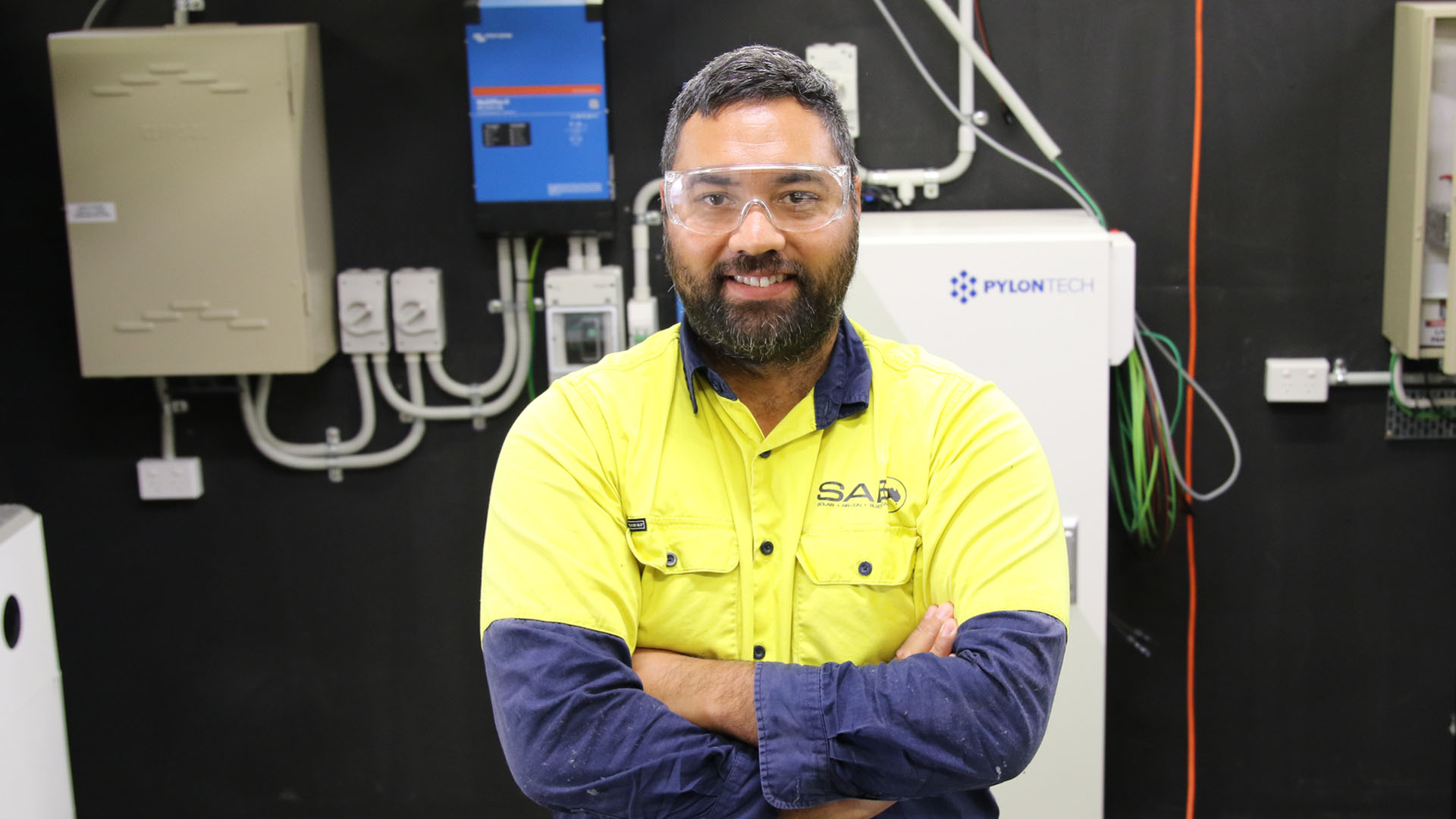 Image of electrician Jordan in front of batteries