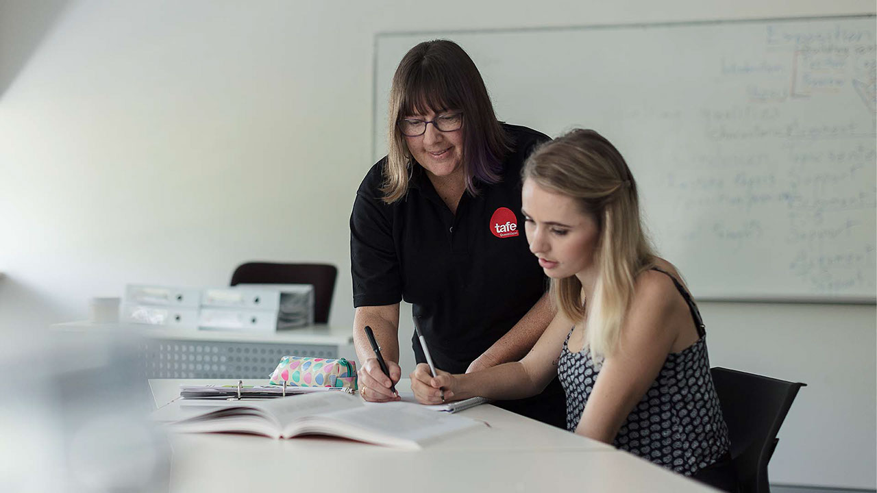A TAFE Queensland teacher working with a student
